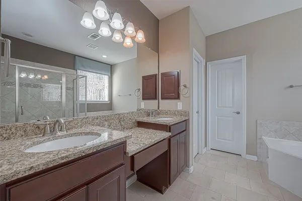 a bathroom with a granite countertop sink a toilet and shower