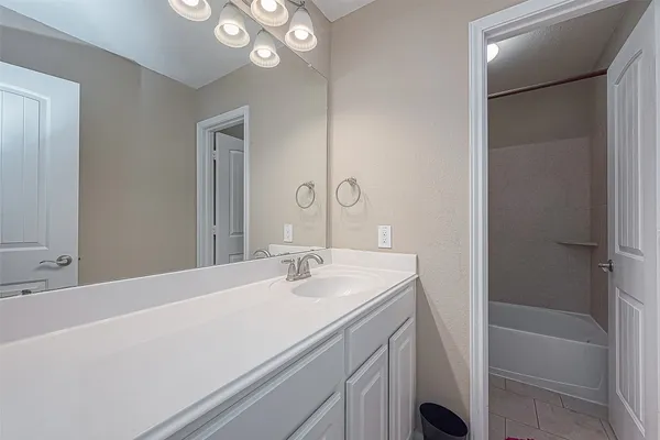 a bathroom with a tub sink and mirror