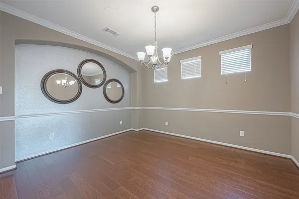a view of empty room with wooden floor and window