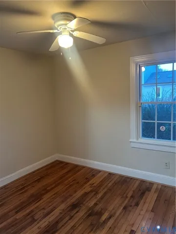 a view of a room with wooden floor and a ceiling fan