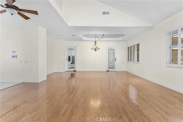 a view of an empty room with window and wooden floor