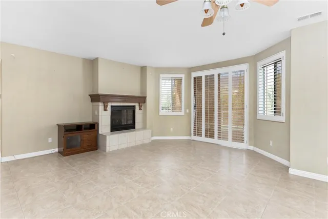 an empty room with wooden floor ceiling fan