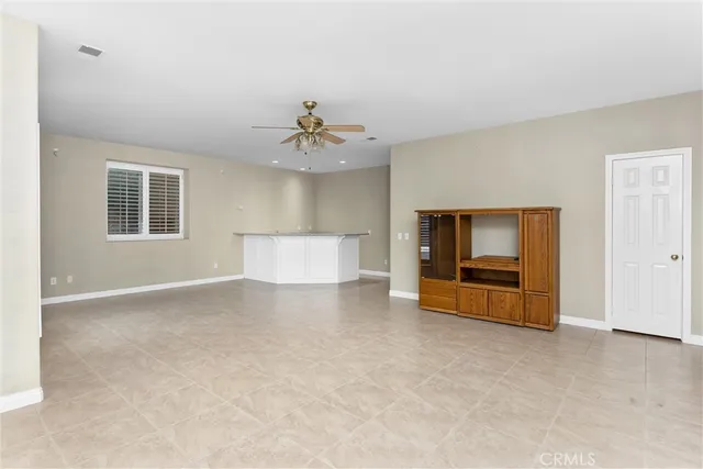 a view of a big room with wooden floor and a chandelier fan
