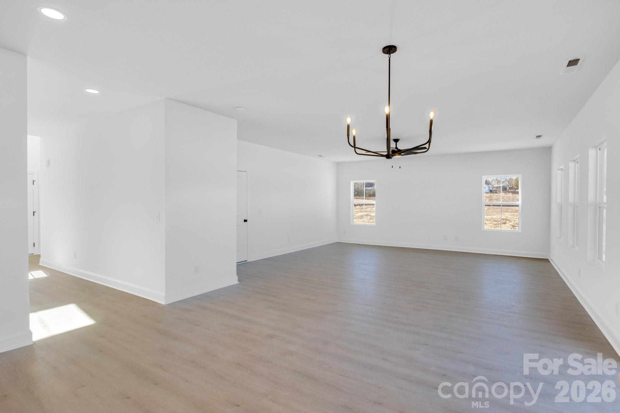 1335 Winged Way, Unit 4 Kannapolis, NC 28083 - Photo 10 of 29 a view of a room with wooden floor ceiling fan and windows