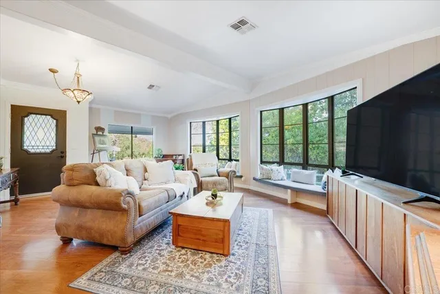 a living room with furniture large window and a flat screen tv