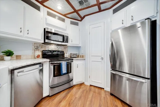 a kitchen with stainless steel appliances a refrigerator sink and microwave