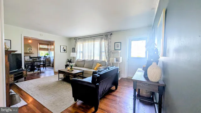 a living room with furniture a flat screen tv and a window