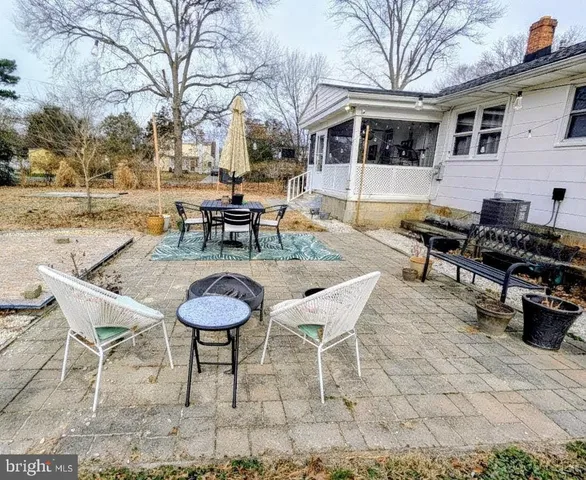 a backyard of a house with barbeque oven table and chairs