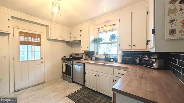 a kitchen with stainless steel appliances a sink stove and cabinets