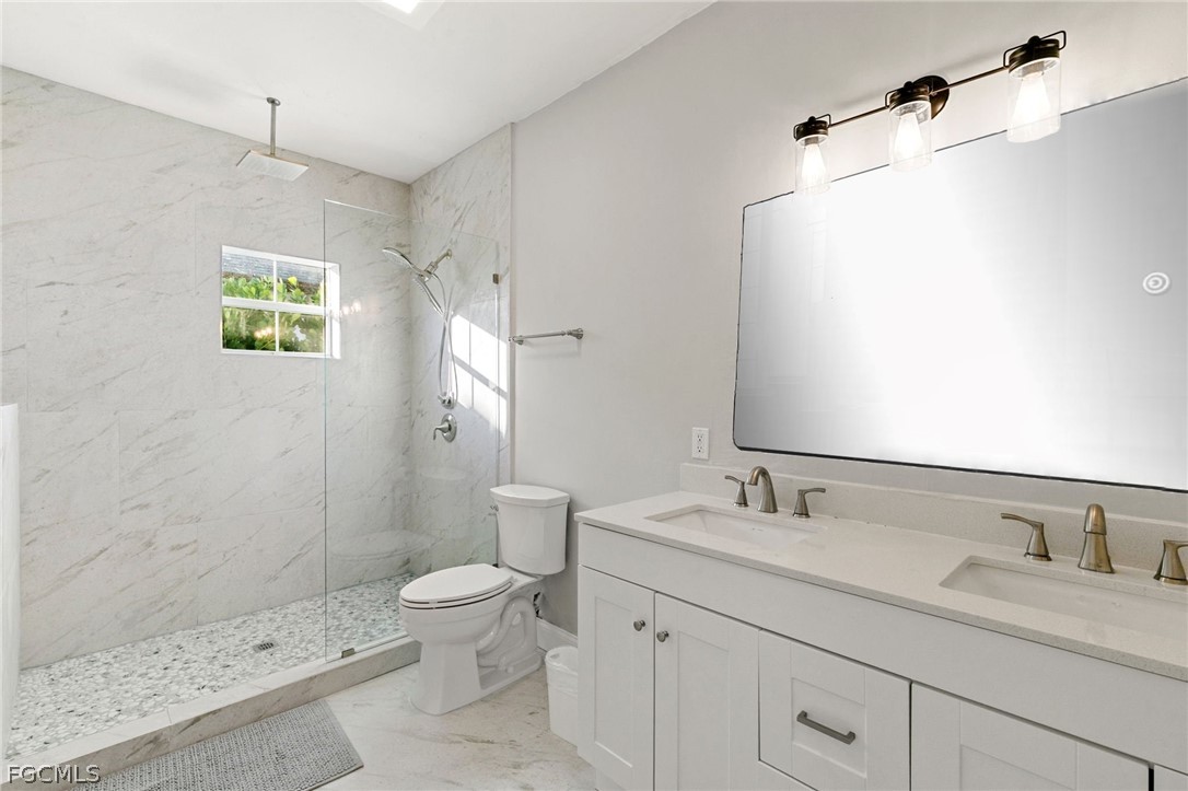 317 3rd Avenue Marco Island, FL 34145 - Photo 13 of 29 a bathroom with a granite countertop sink a toilet and a mirror
