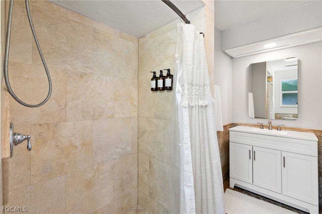 317 3rd Avenue Marco Island, FL 34145 - Photo 19 of 29 a bathroom with a granite countertop sink a mirror and a shower