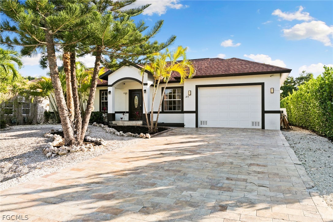 317 3rd Avenue Marco Island, FL 34145 - Photo 2 of 29 a front view of a house with a yard
