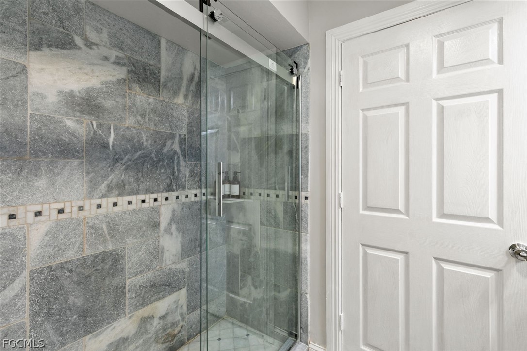 317 3rd Avenue Marco Island, FL 34145 - Photo 21 of 29 a bathroom with a glass shower door