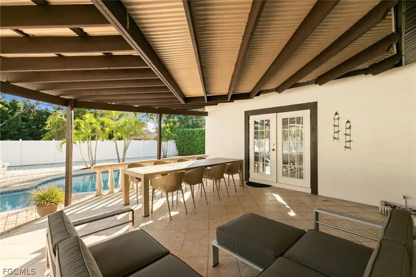 a view of a patio with table and chairs potted plants with wooden floor and fence