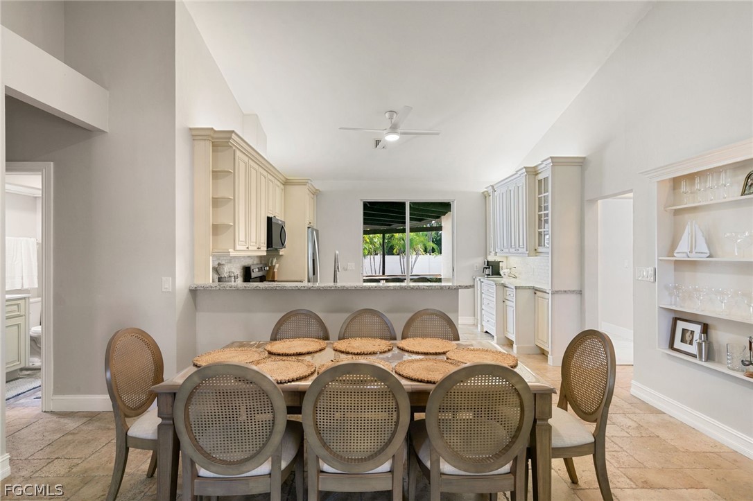 317 3rd Avenue Marco Island, FL 34145 - Photo 6 of 29 a dining room with kitchen island stainless steel appliances furniture a large window and wooden floor