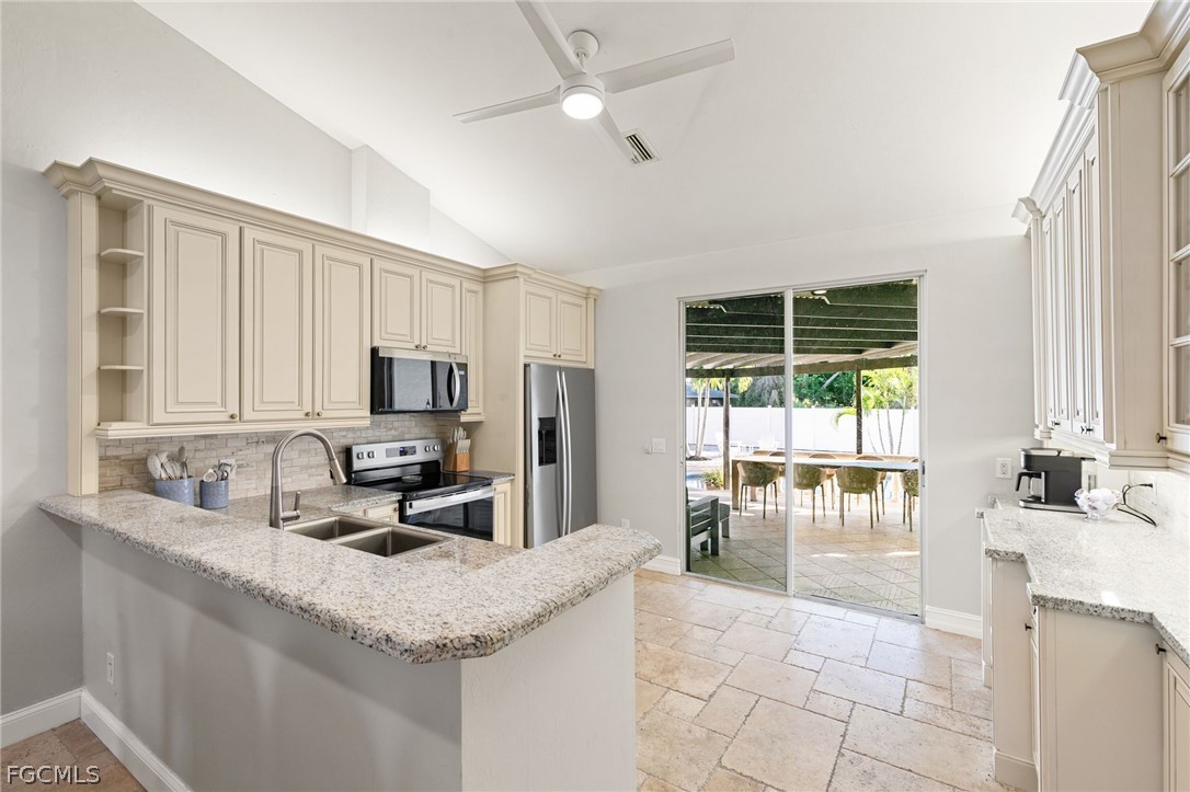 317 3rd Avenue Marco Island, FL 34145 - Photo 7 of 29 a kitchen with granite countertop a sink a counter top space and stainless steel appliances