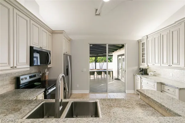 a kitchen with granite countertop a sink and a stove top oven