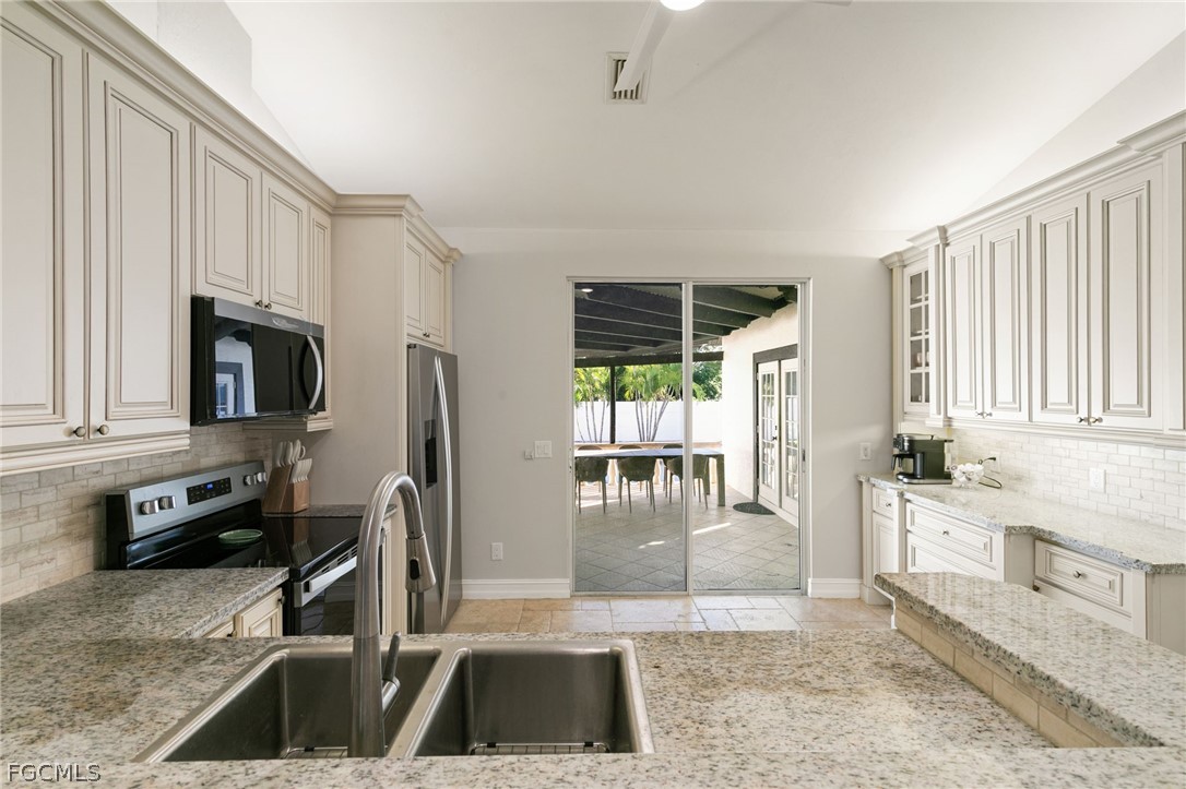 317 3rd Avenue Marco Island, FL 34145 - Photo 8 of 29 a kitchen with granite countertop a sink and a stove top oven