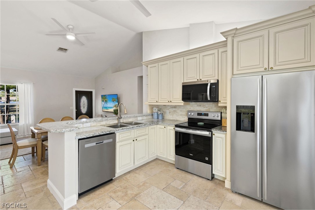 317 3rd Avenue Marco Island, FL 34145 - Photo 9 of 29 a kitchen with stainless steel appliances granite countertop a stove top oven a sink and a refrigerator