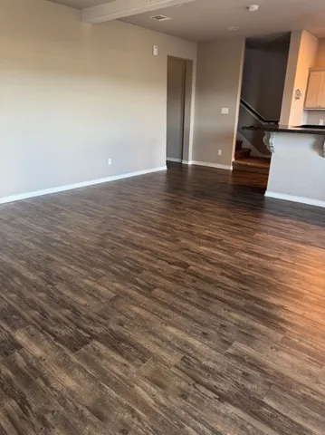 a view of an empty room with wooden floor