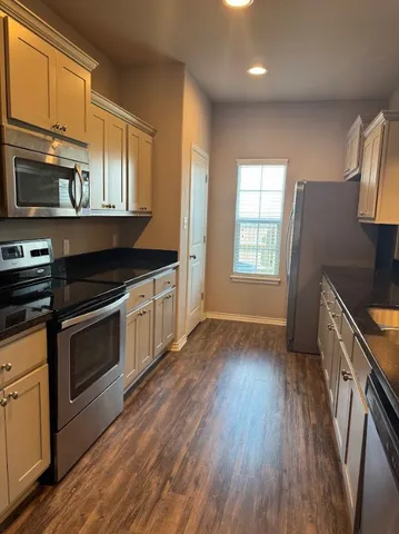 a kitchen with stainless steel appliances granite countertop a stove a sink and a microwave