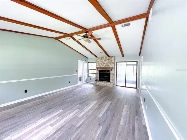 a view of empty room with wooden floor and fireplace