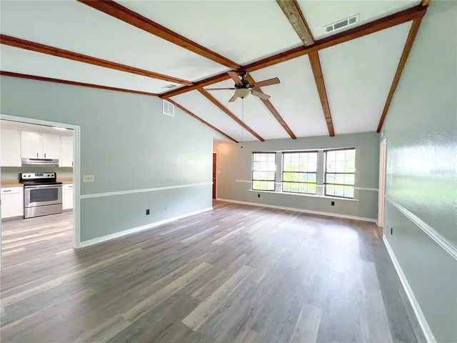 an empty room with a window and a ceiling fan