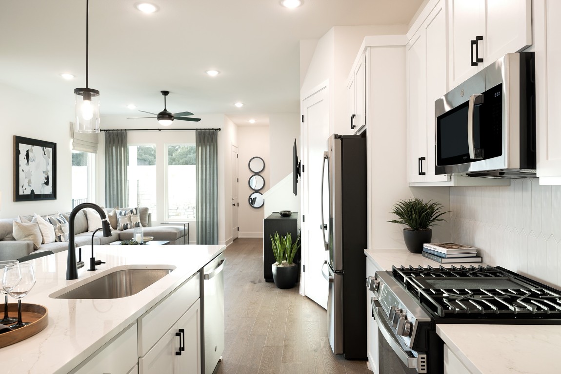 1310 Sweet Bark Street Austin, TX 78745 - Photo 7 of 13 a kitchen with a sink and stainless steel appliances