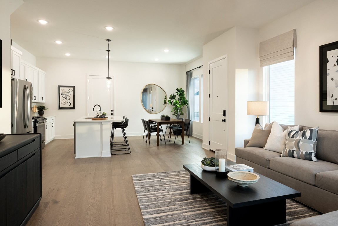 1310 Sweet Bark Street Austin, TX 78745 - Photo 10 of 13 a living room with furniture kitchen view and a wooden floor