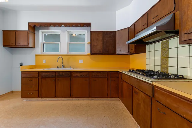 a kitchen with wooden cabinets and a stove top oven