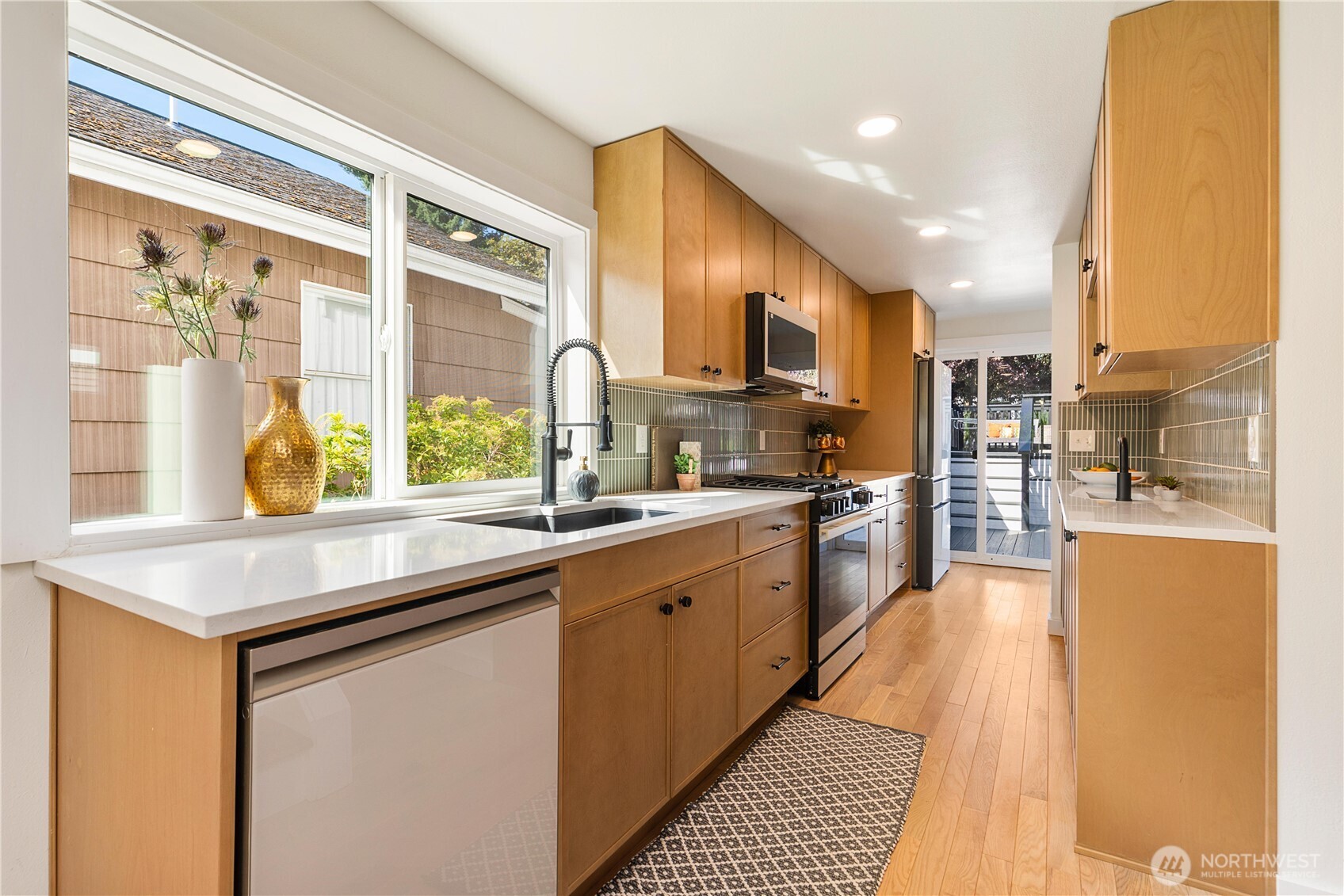6031 McKinley Place North Seattle, WA 98103 - Photo 14 of 40 a kitchen with stainless steel appliances a sink a stove and a refrigerator