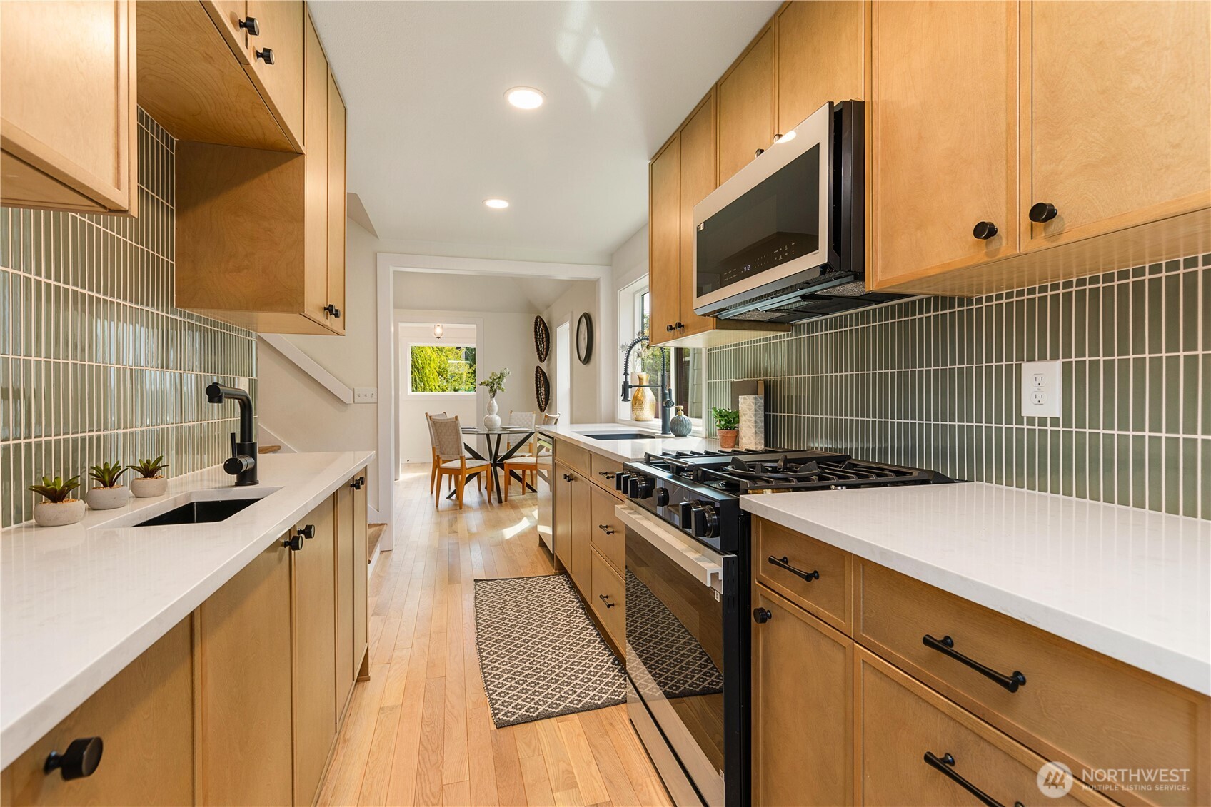 6031 McKinley Place North Seattle, WA 98103 - Photo 15 of 40 a kitchen with stainless steel appliances a stove a sink a oven and wooden cabinets