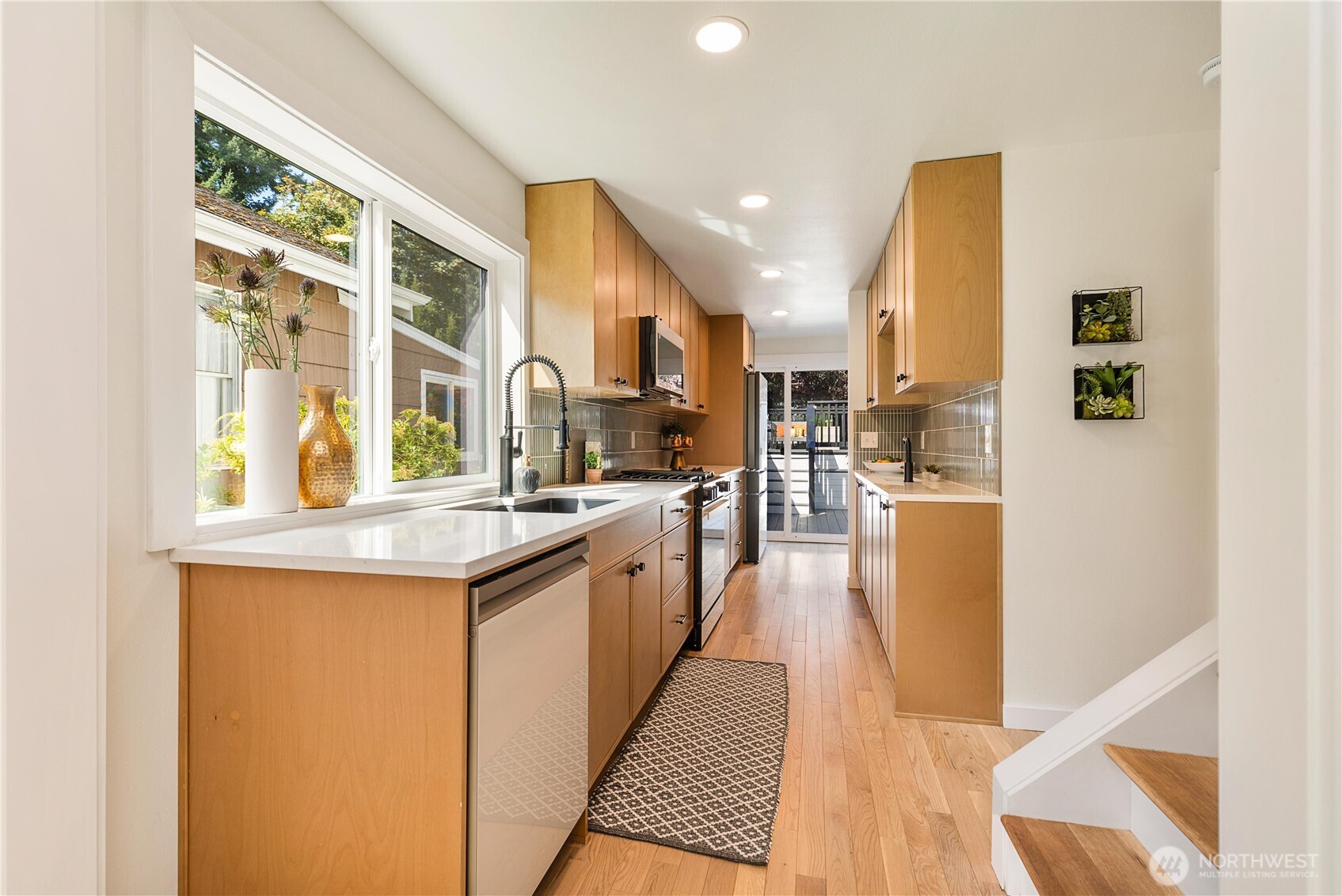6031 McKinley Place North Seattle, WA 98103 - Photo 16 of 40 a kitchen with stainless steel appliances granite countertop a stove and a sink