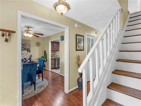 a view of a hallway with wooden floor and furniture