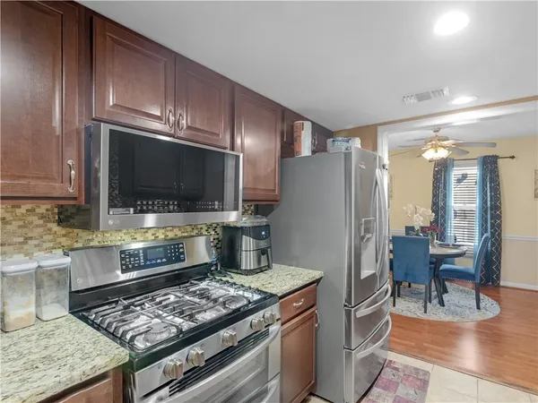 a kitchen with stainless steel appliances granite countertop a stove refrigerator and cabinets