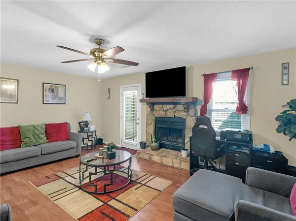 a living room with furniture a fireplace and a flat screen tv