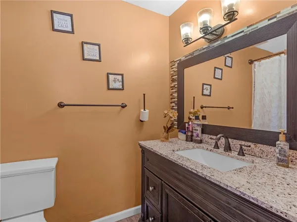 a bathroom with a granite countertop sink and a mirror