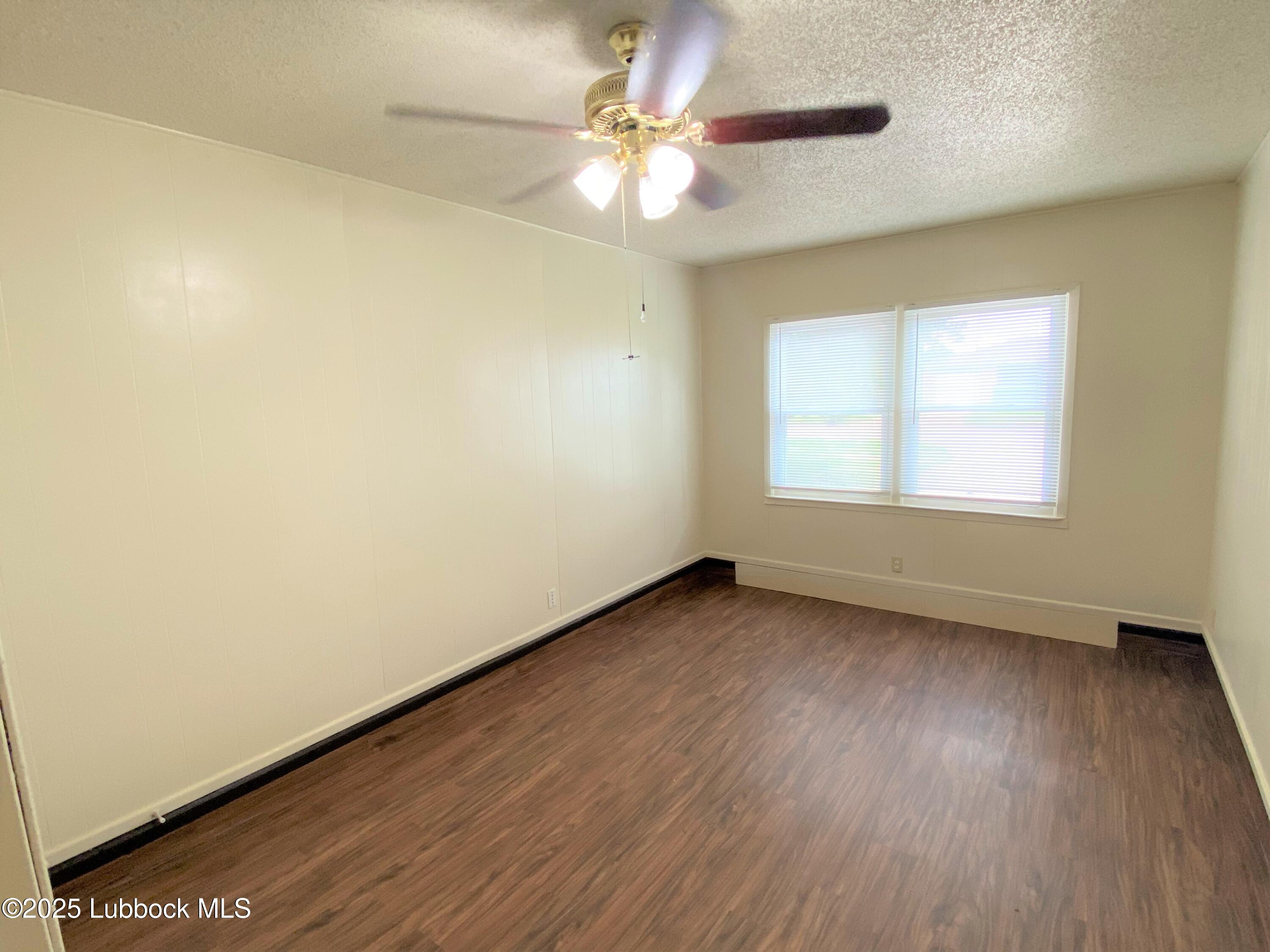 5207 39th Street Lubbock, TX 79414 - Photo 6 of 20 an empty room with a window and a ceiling fan