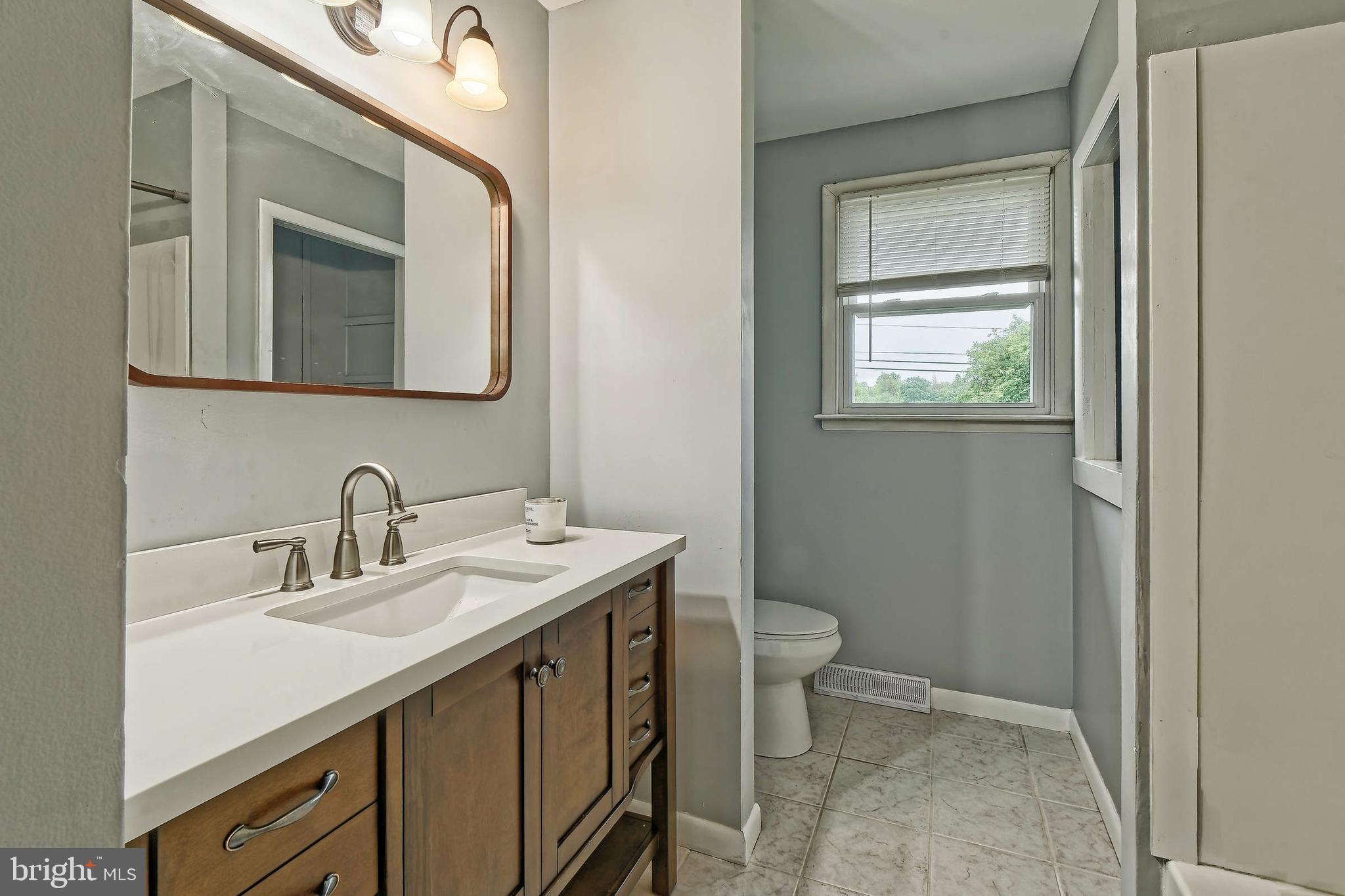 3176 Hance Bridge Road Vineland, NJ 08361 - Photo 13 of 24 a bathroom with a sink a toilet and a mirror