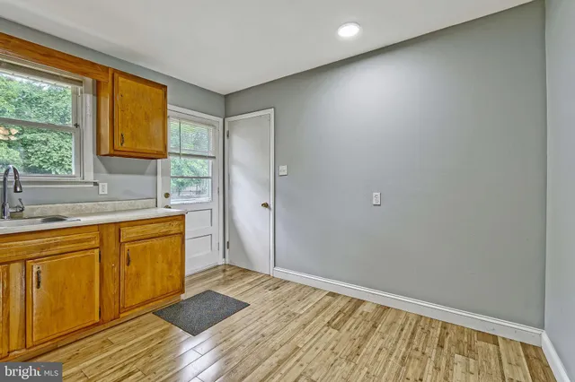a bathroom with a sink a mirror and next to a window