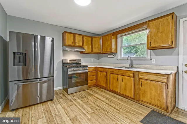 a kitchen with stainless steel appliances granite countertop a refrigerator sink and cabinets