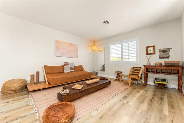 a living room with furniture a flat screen tv and a window
