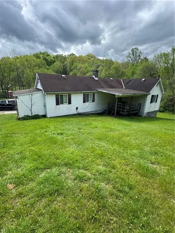 a backyard of a house with table and chairs