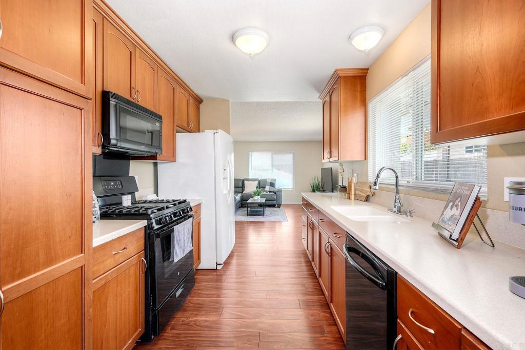 1114 Red Hawk Way San Marcos, CA 92078 - Photo 14 of 59 a kitchen with stainless steel appliances granite countertop a sink stove and refrigerator