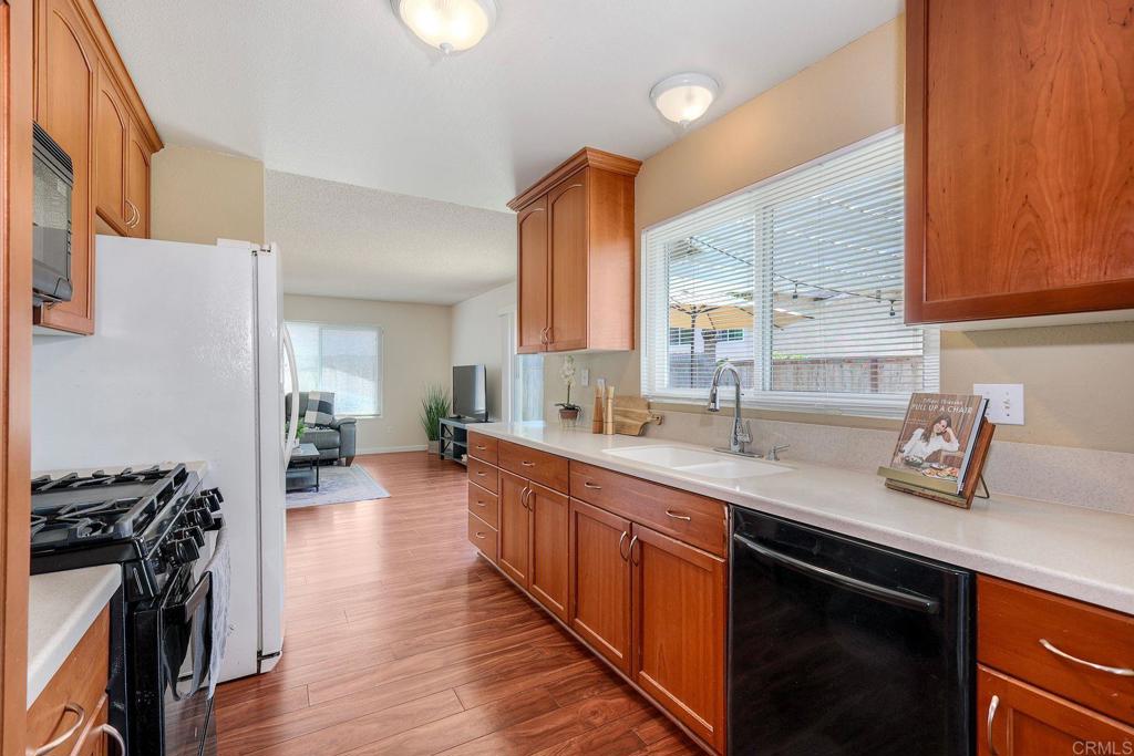 1114 Red Hawk Way San Marcos, CA 92078 - Photo 15 of 59 a kitchen with stainless steel appliances a sink dishwasher stove and wooden floor