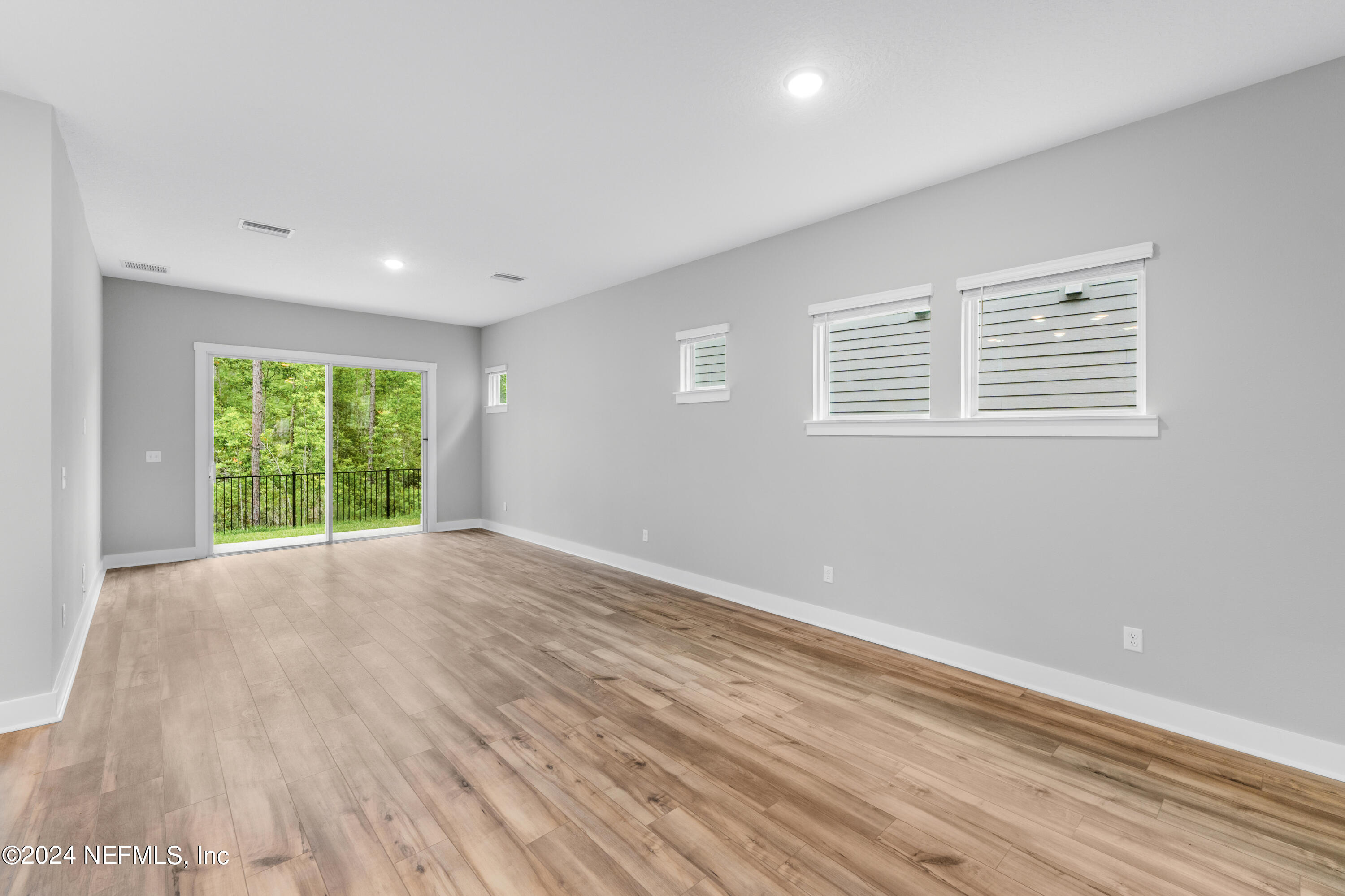 10021 Element Road Jacksonville, FL 32256 - Photo 12 of 18 a view of an empty room with wooden floor and a window