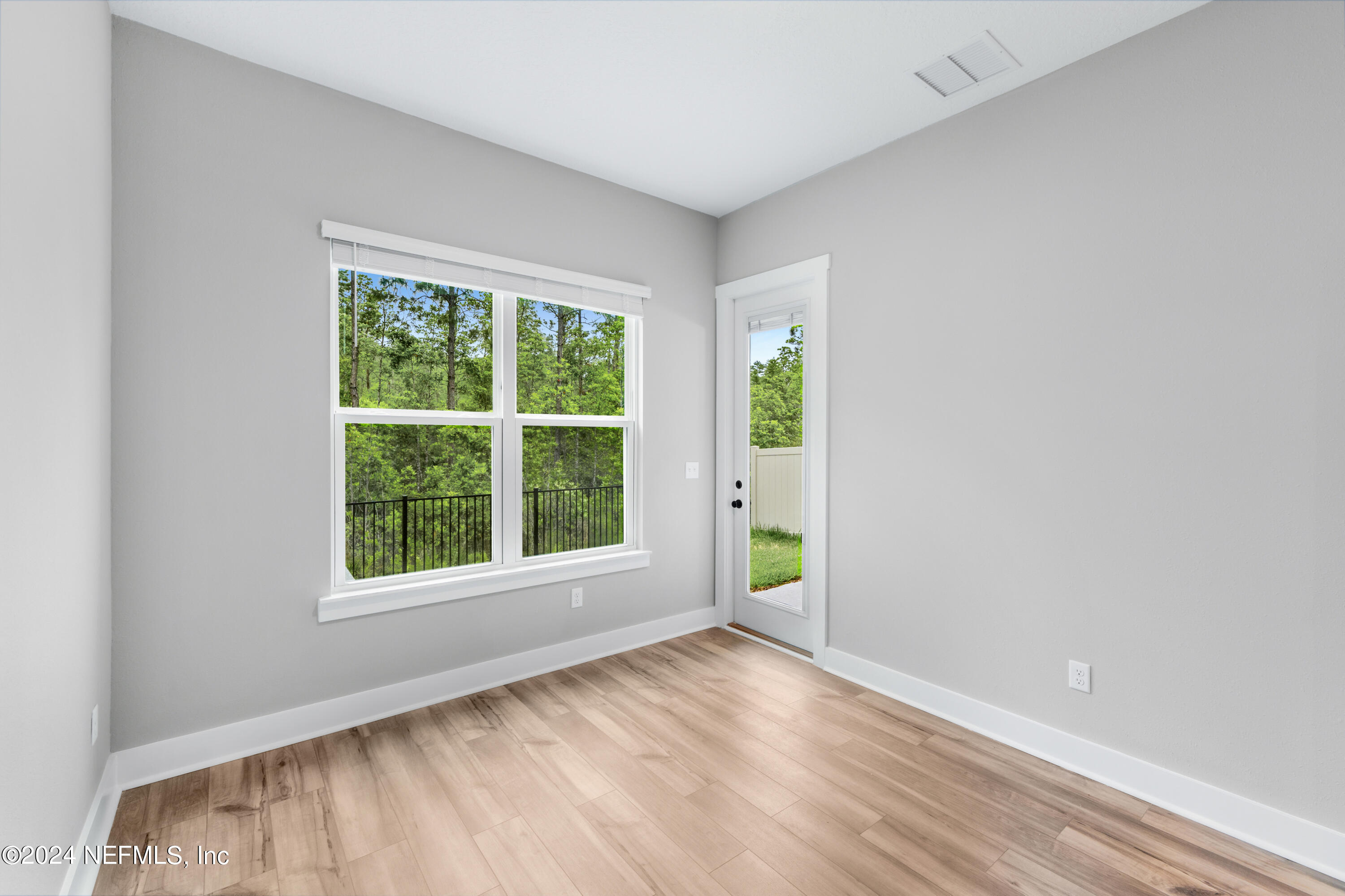 10021 Element Road Jacksonville, FL 32256 - Photo 13 of 18 an empty room with wooden floor and windows