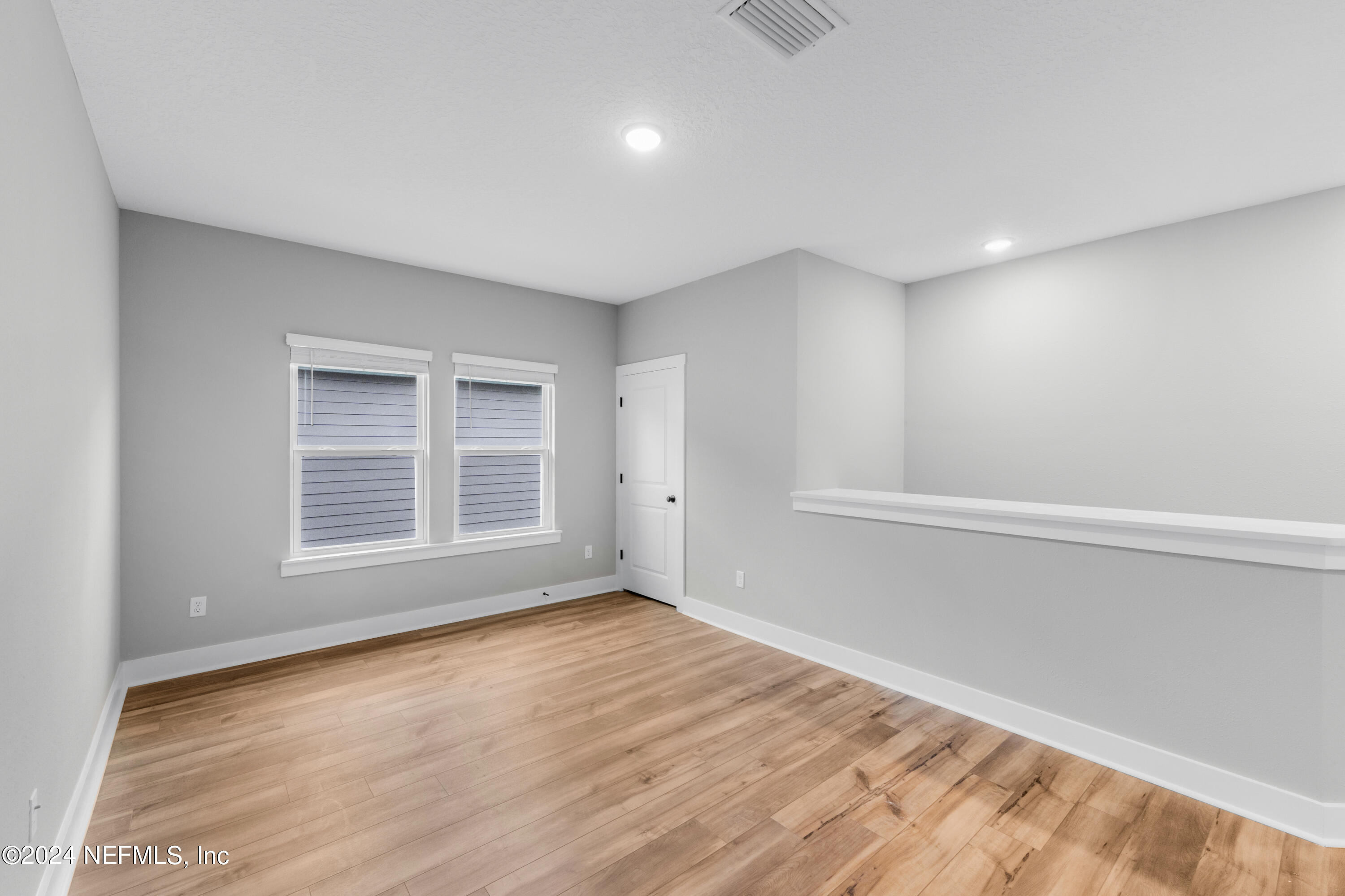 10021 Element Road Jacksonville, FL 32256 - Photo 14 of 18 a view of an empty room with wooden floor and a window