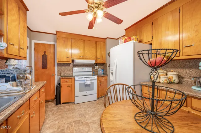 a kitchen with stainless steel appliances kitchen island granite countertop a table chairs in it and wooden floors
