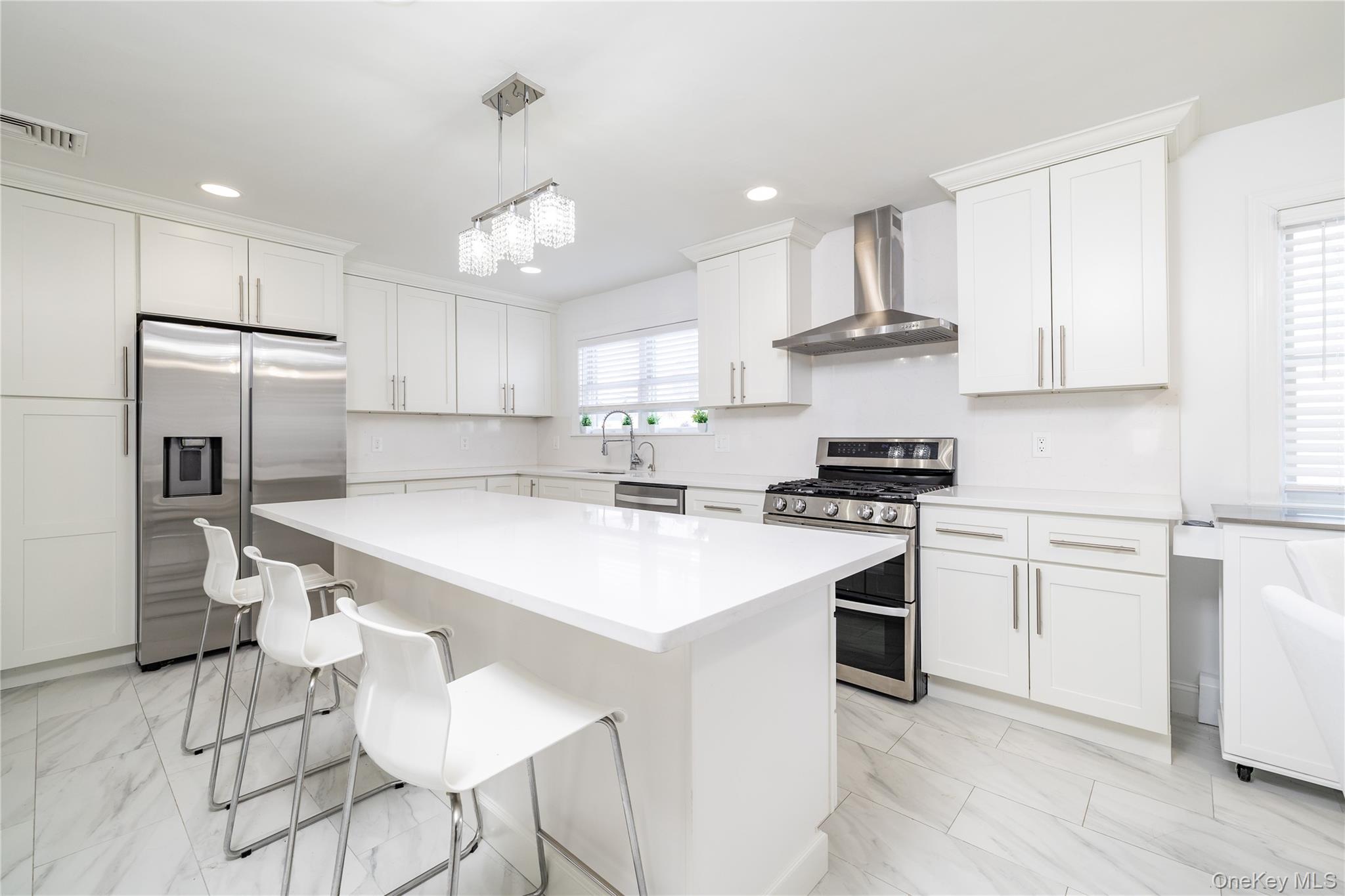 458 East Pine Street Long Beach, NY 11561 - Photo 4 of 26 a kitchen with kitchen island a stove a sink and a refrigerator